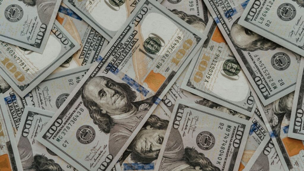 Close-up of American 100 dollar bills scattered, highlighting wealth and currency concepts.