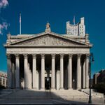 Front view of the Supreme Court building in New York City with blue skies.