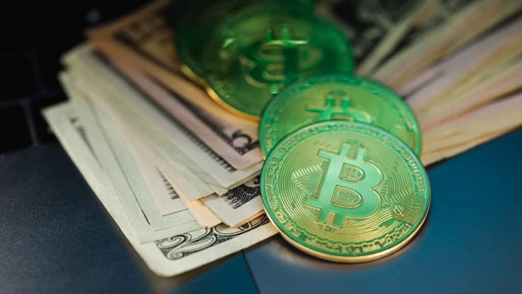 Close-up of Bitcoin with US dollars symbolizing digital and paper currency.