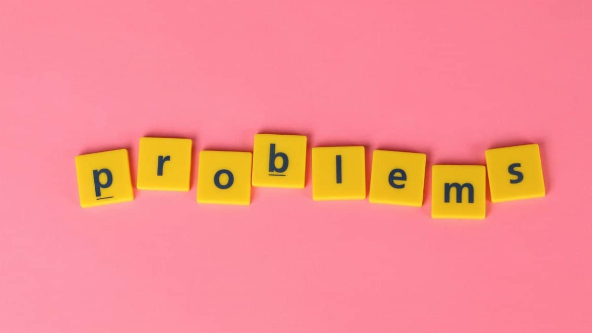 Yellow letter tiles spelling 'problems' on a contrasting pink background. Perfect for creative design projects.