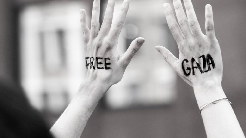 Hands raised with 'Free Gaza' message during a protest, symbolic and expressive.