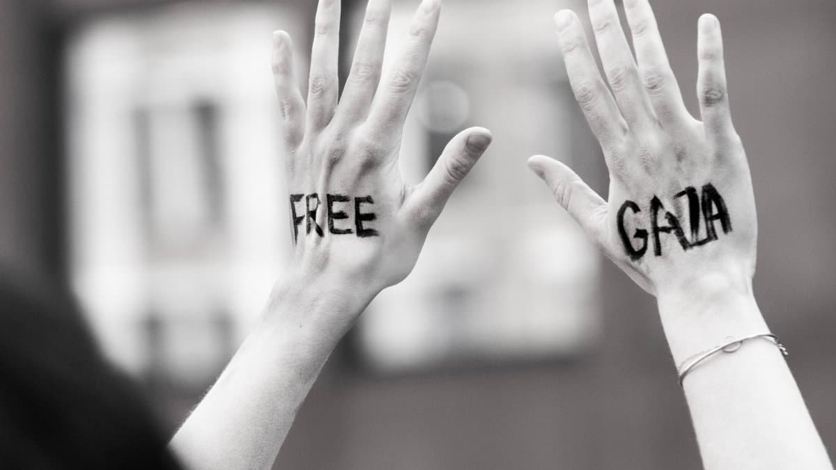 Hands raised with 'Free Gaza' message during a protest, symbolic and expressive.