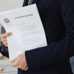 A person holding a divorce decree in an office setting, symbolizing legal proceedings.