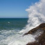 Vivid ocean waves crash against rocky shore in Santa Cruz, Argentina. Perfect for nature and travel imagery.