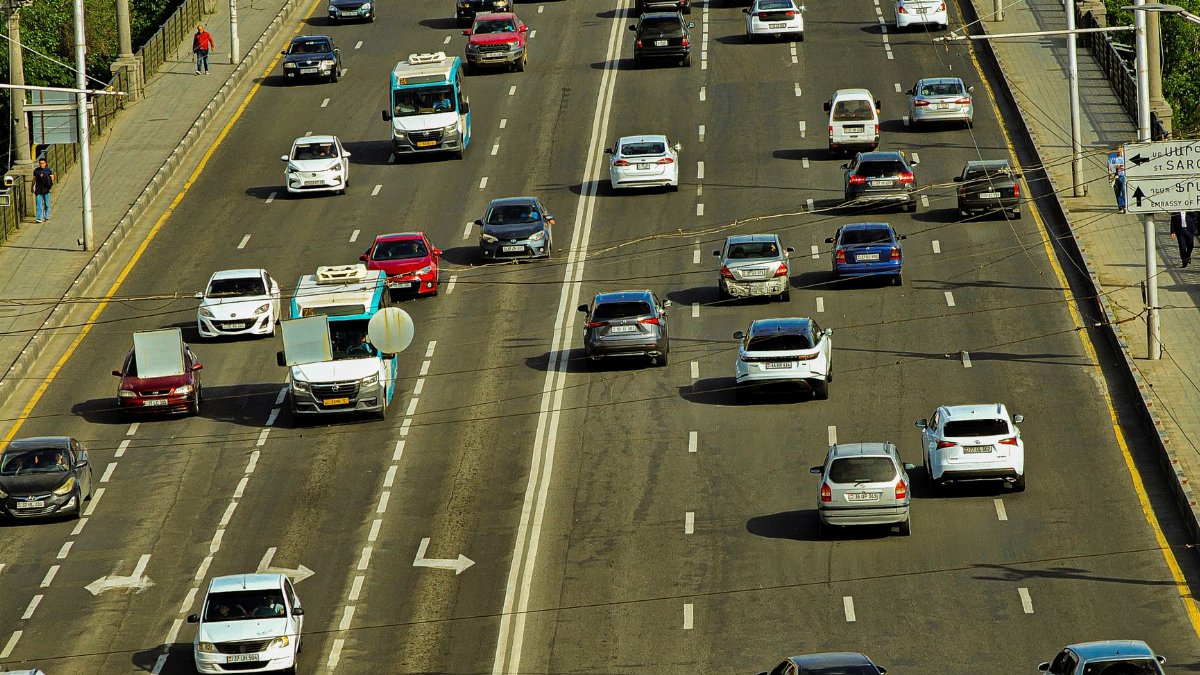 A high-angle view of a busy urban highway with several cars, showcasing city transportation.