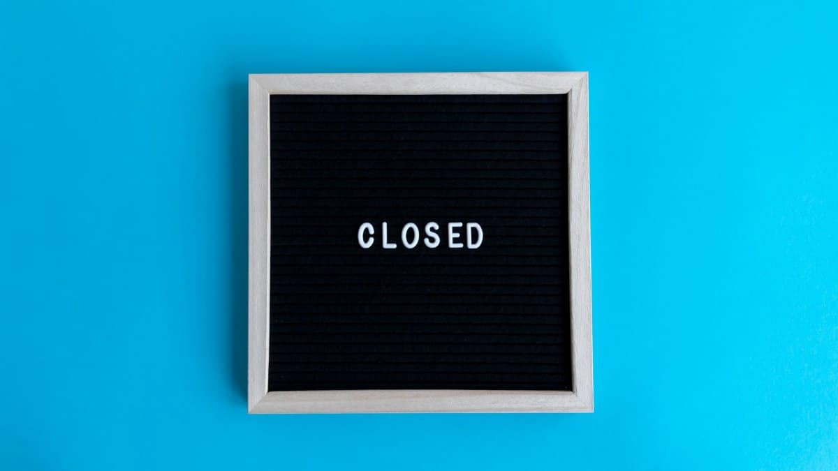 A letter board with 'Closed' displayed against a vibrant blue backdrop, signifying a closure or notice.