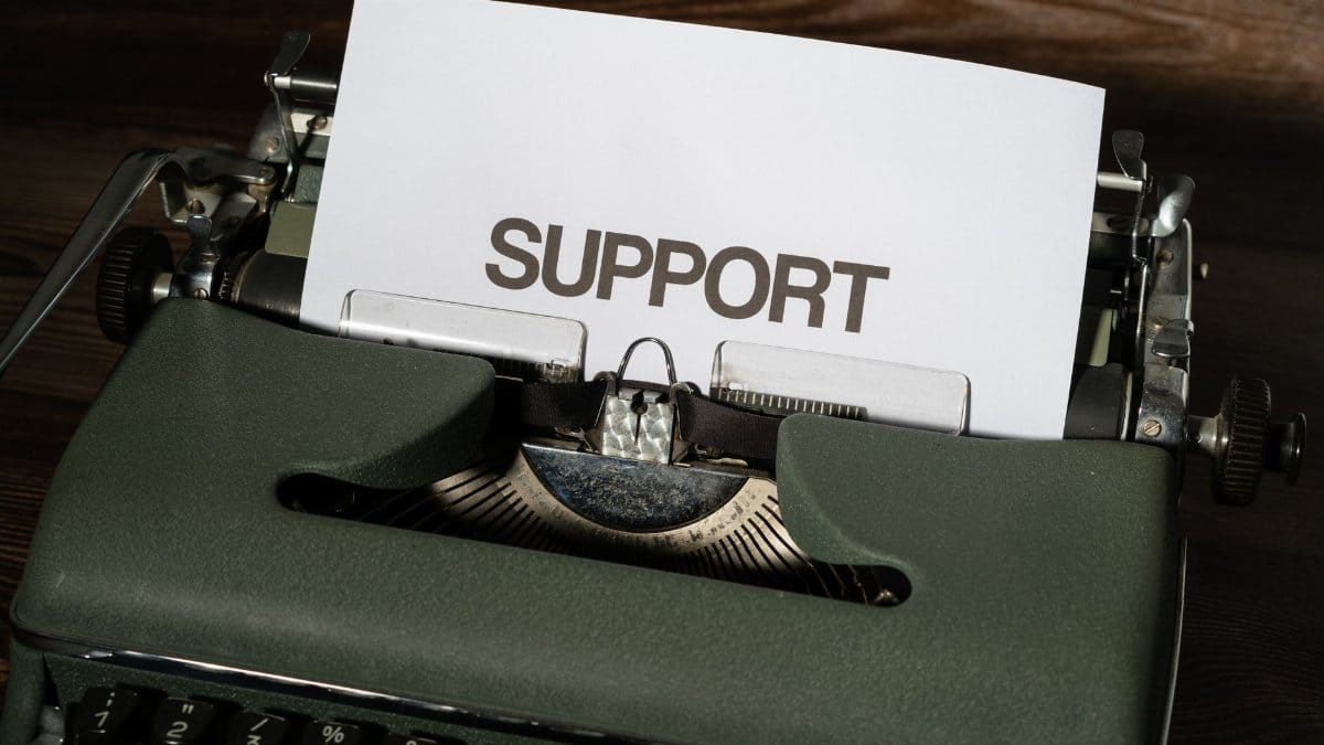 Close-up of vintage typewriter with 'SUPPORT' printed on paper, conveying assistance theme.