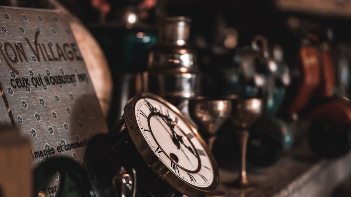 A close-up view of vintage clocks and antique items on a shelf, creating a nostalgic feel.