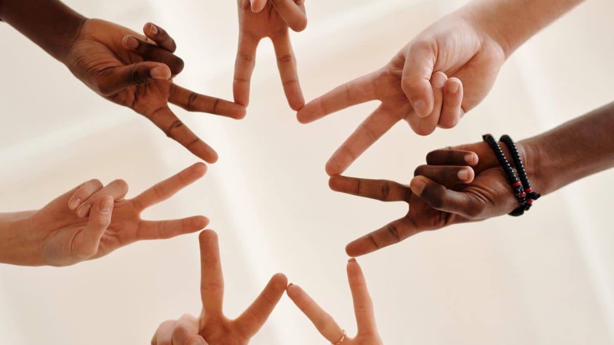 Multicultural hands forming a star shape symbolizing unity and teamwork.