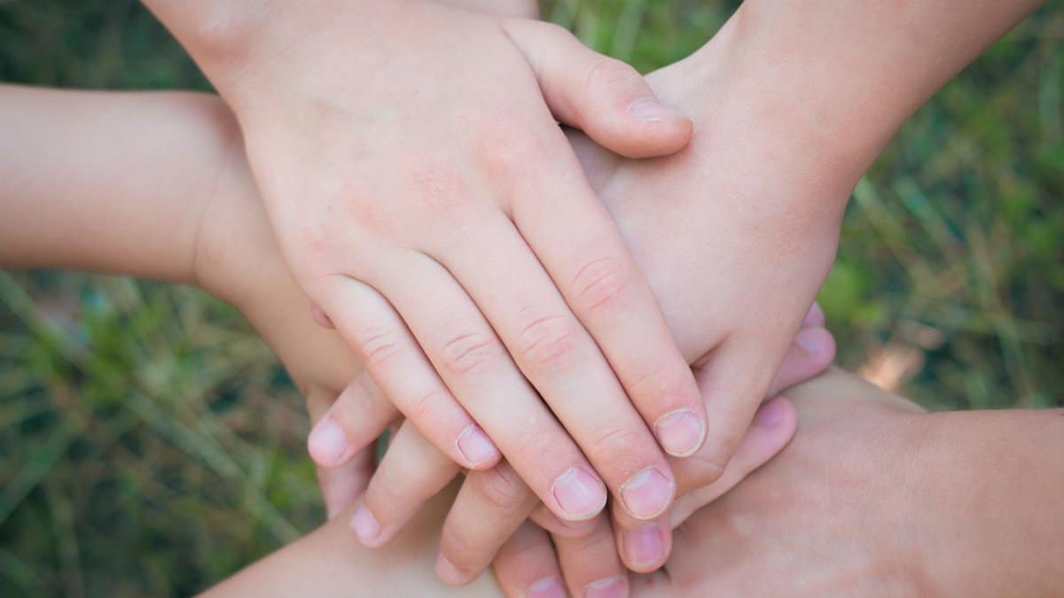 Close-up of diverse hands clasped together symbolizing unity and teamwork.