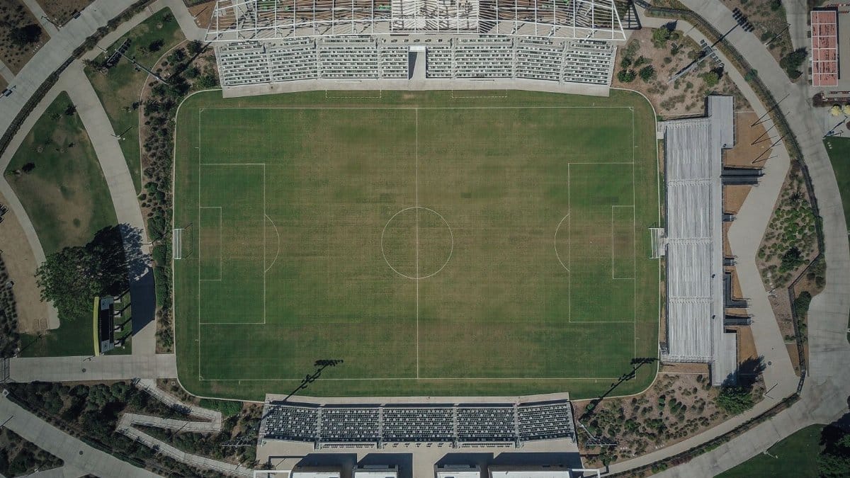 High-angle aerial shot capturing the details of a soccer stadium and surrounding sports complex.