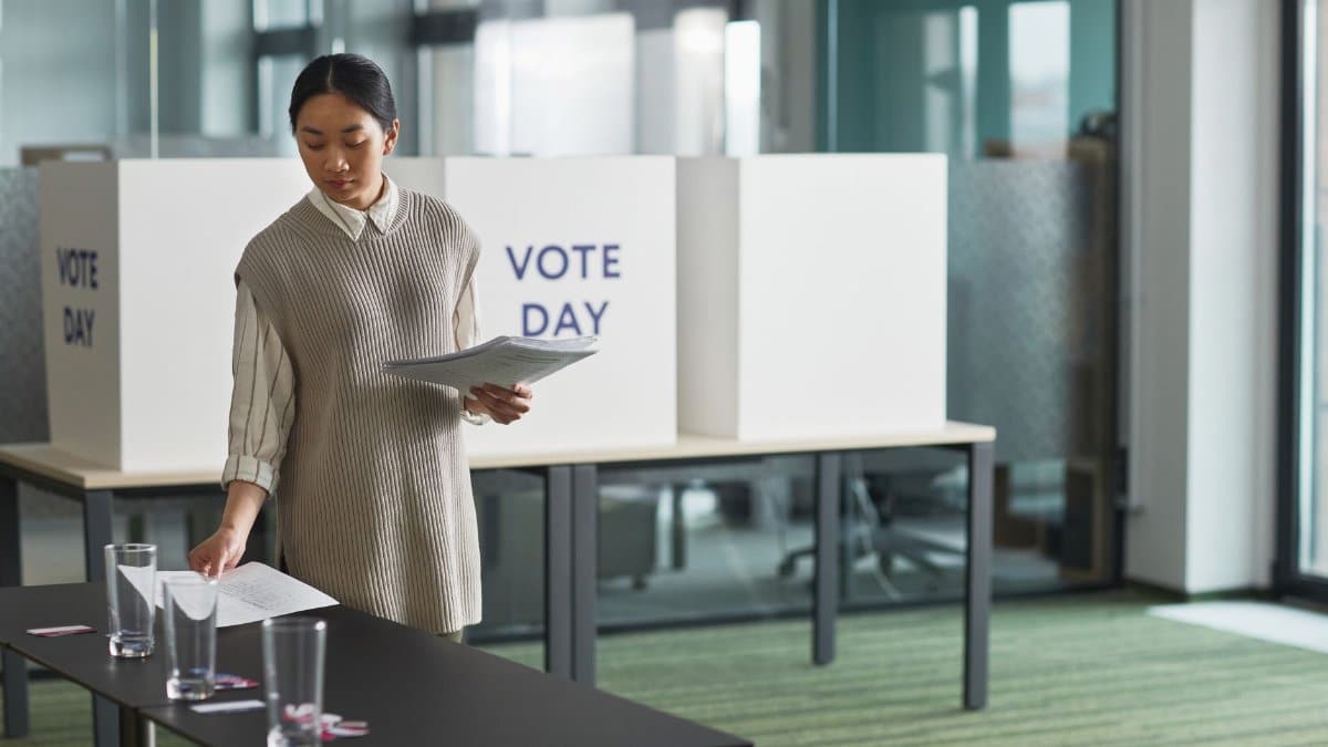 Asian woman preparing voting materials on election day.