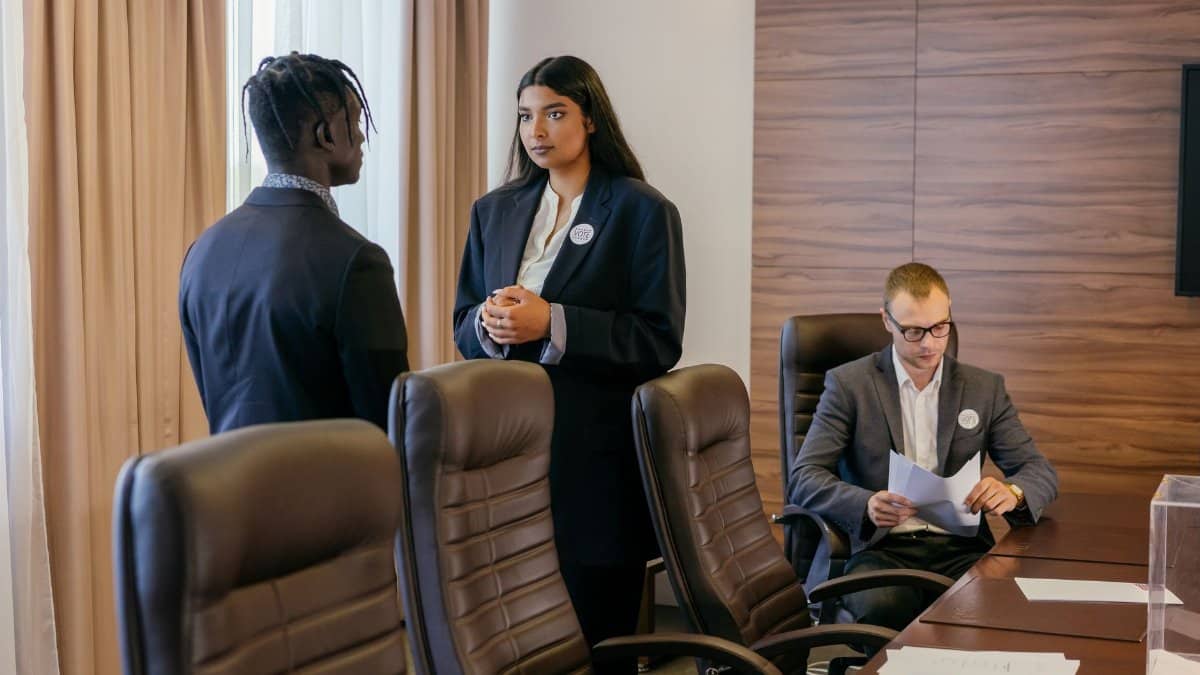 Three professionals discussing business strategy in a modern conference room.