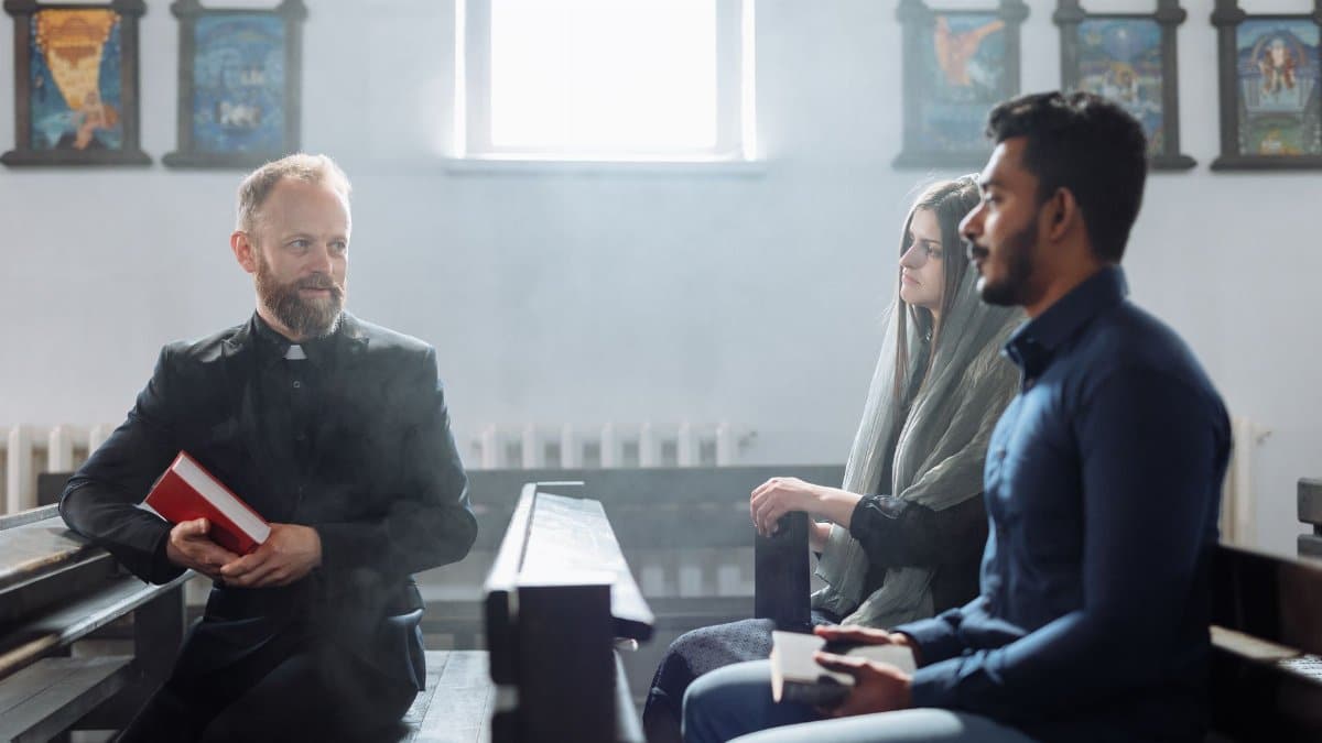 A priest converses with two people inside a church, highlighting religious dialogue and community.