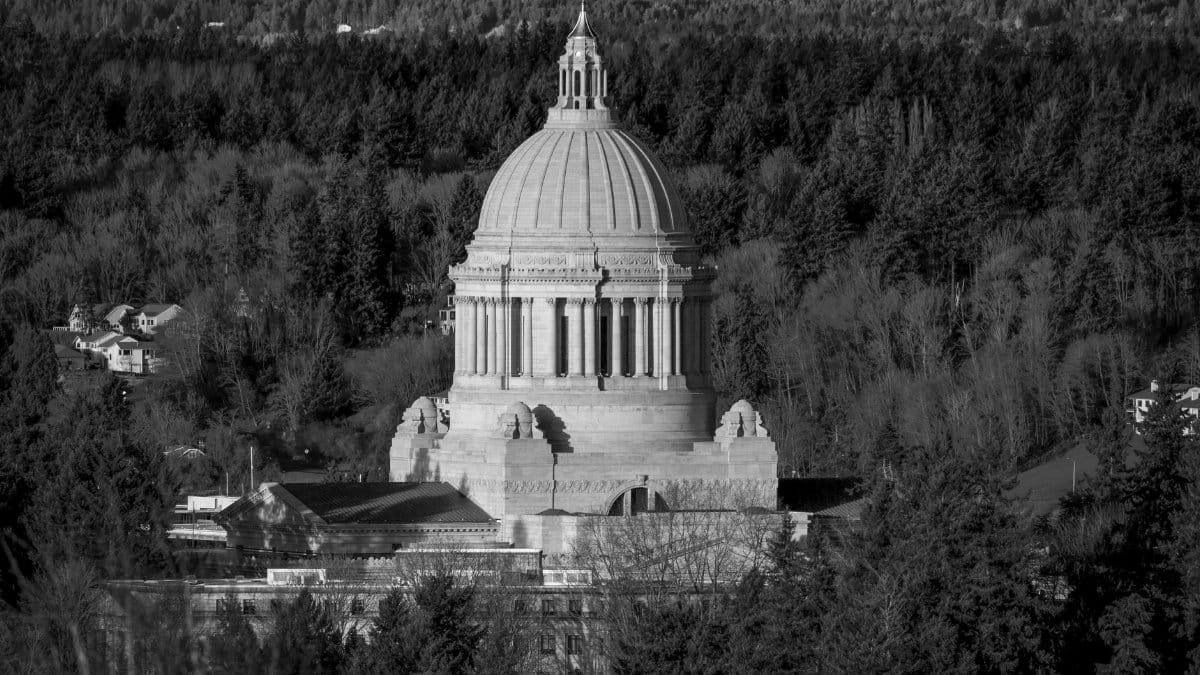 Elegant black and white photo of the Washington State Capitol dome surrounded by trees in Olympia.