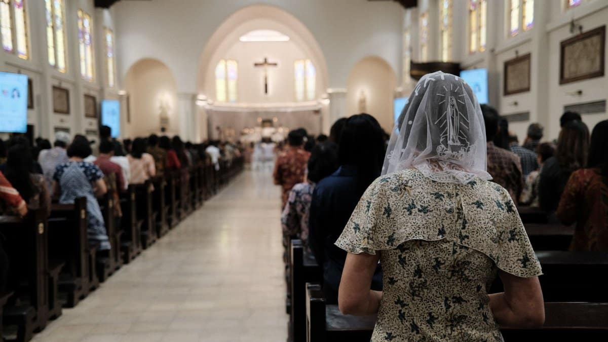 People gathered in an Indonesian church for a Mass service, showcasing community and faith.