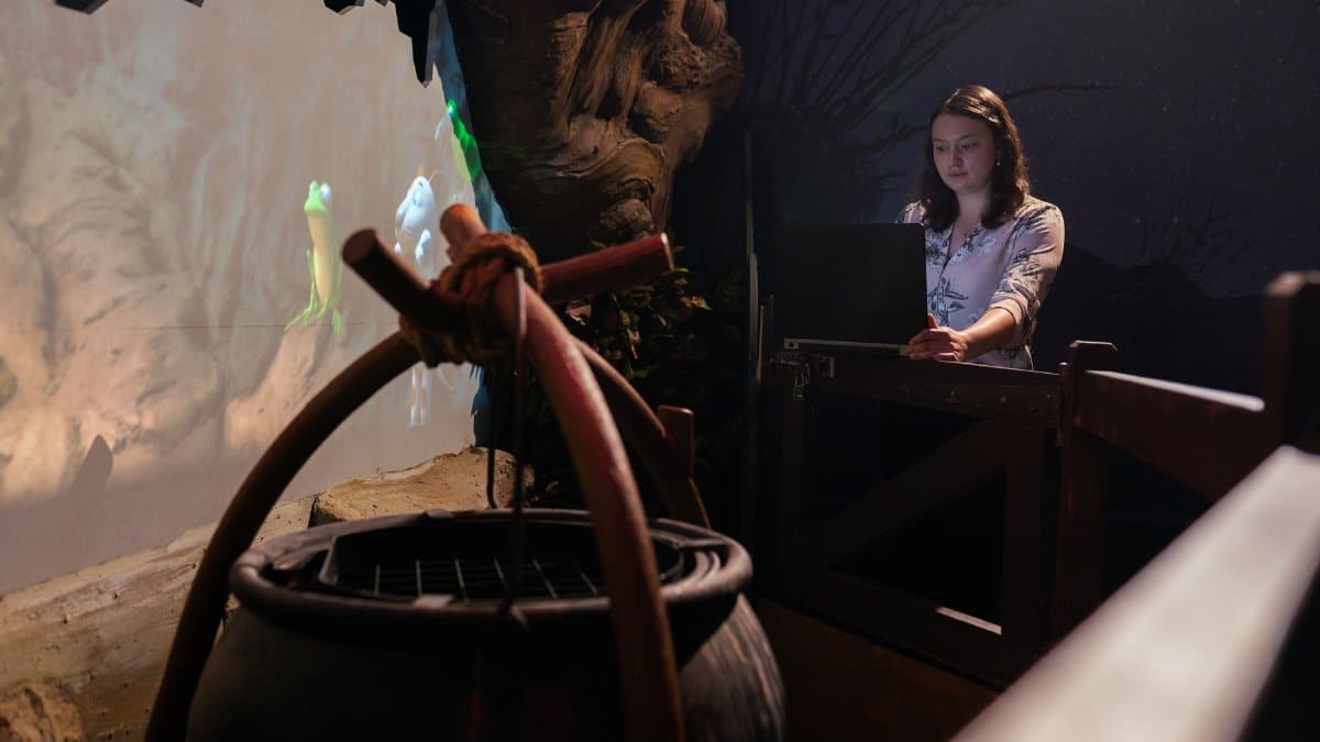 A woman uses a laptop at an interactive display, creating a futuristic ambiance indoors.