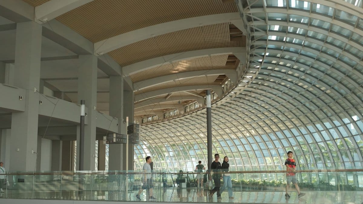 Modern architecture with curved glass walls at Marina Bay Sands, Singapore, capturing daily life indoors.