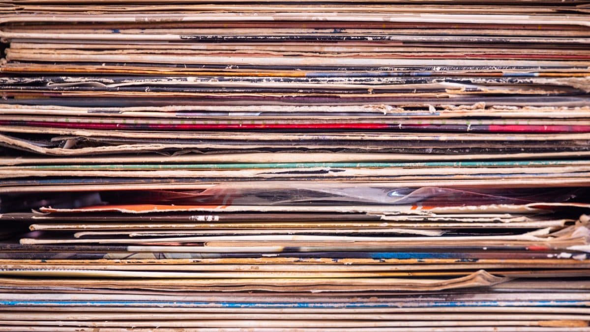Close-up view of a stack of vintage vinyl records with colorful album covers.