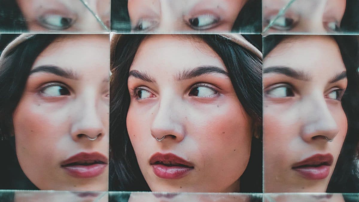 Artistic portrait of a woman with multiple reflections in mirrors, creating a unique visual effect.
