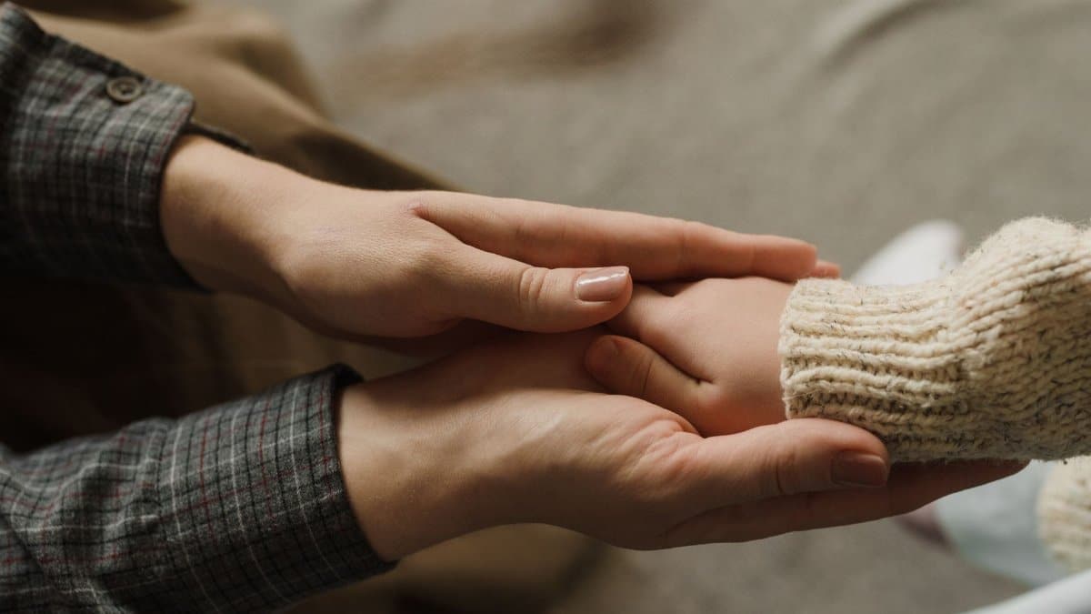 Heartwarming image showing adult and child holding hands, symbolizing affection and care.