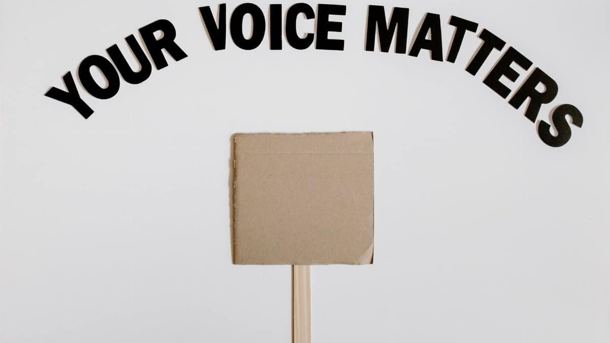 Image of a blank protest sign with 'Your Voice Matters' text overhead on a white background.