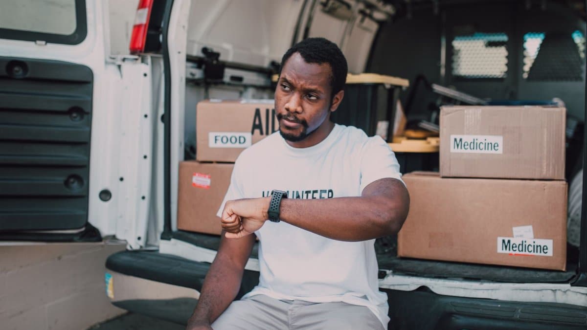 A volunteer organizing aid deliveries including food and medicine from a van.
