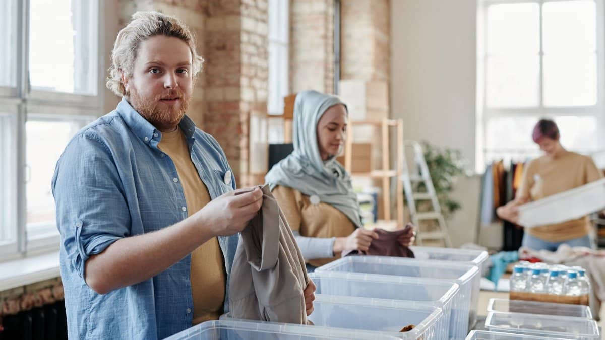 Volunteers sorting clothes in a donation center, promoting community support and teamwork.
