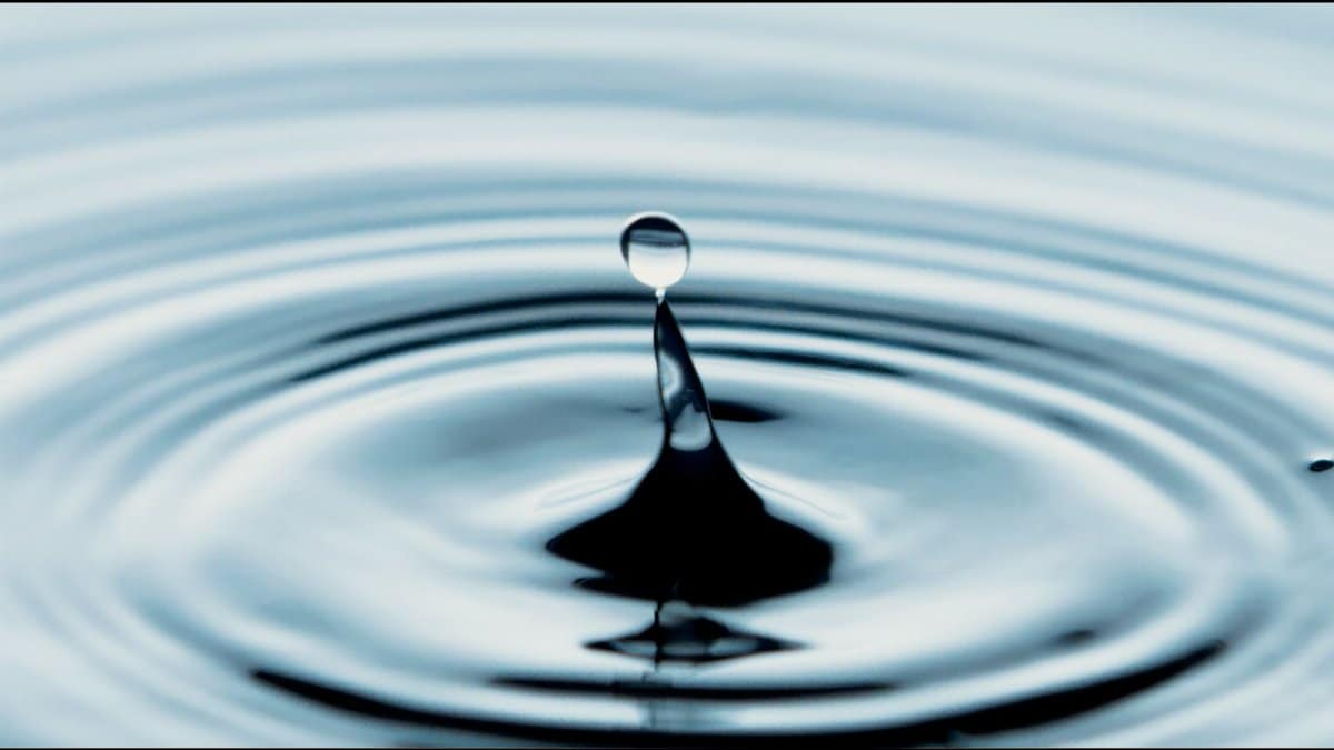 Captivating close-up of a water drop splash creating ripples, perfect for backgrounds.