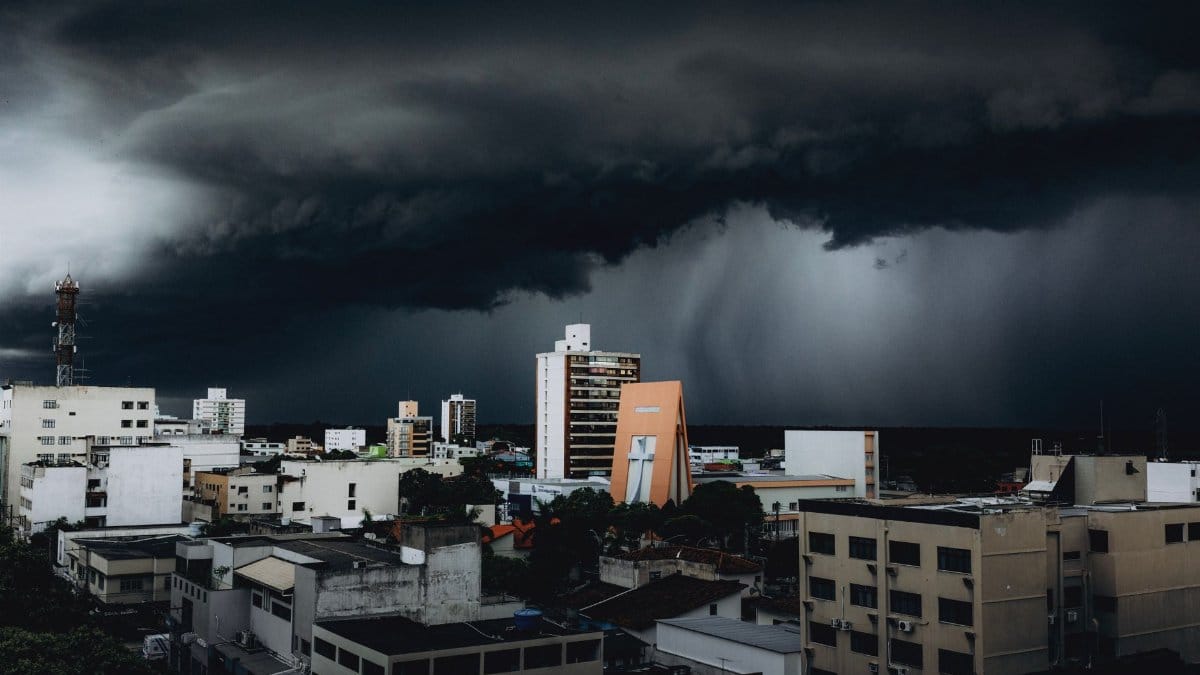 Dramatic storm clouds hover over city skyscrapers, creating a moody urban landscape contrast.