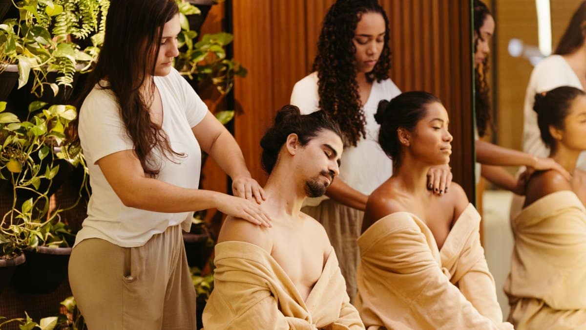 Two clients enjoy a relaxing massage from professional therapists in a spa setting, promoting wellness and relaxation.