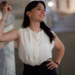 Confident woman posing in an elegant outfit on a night in Milan, Italy.