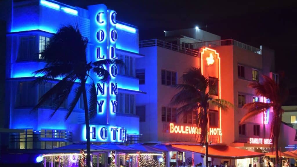 Lively neon-lit hotels illuminate the Miami Beach nightlife, highlighting Art Deco architecture.