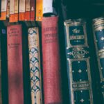 Close-up of a vintage book collection on a wooden shelf, showcasing classic literature.