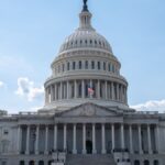 Stunning architectural shot of the US Capitol under a clear blue sky.