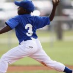 Young player pitching in a youth baseball game on a sunny day.