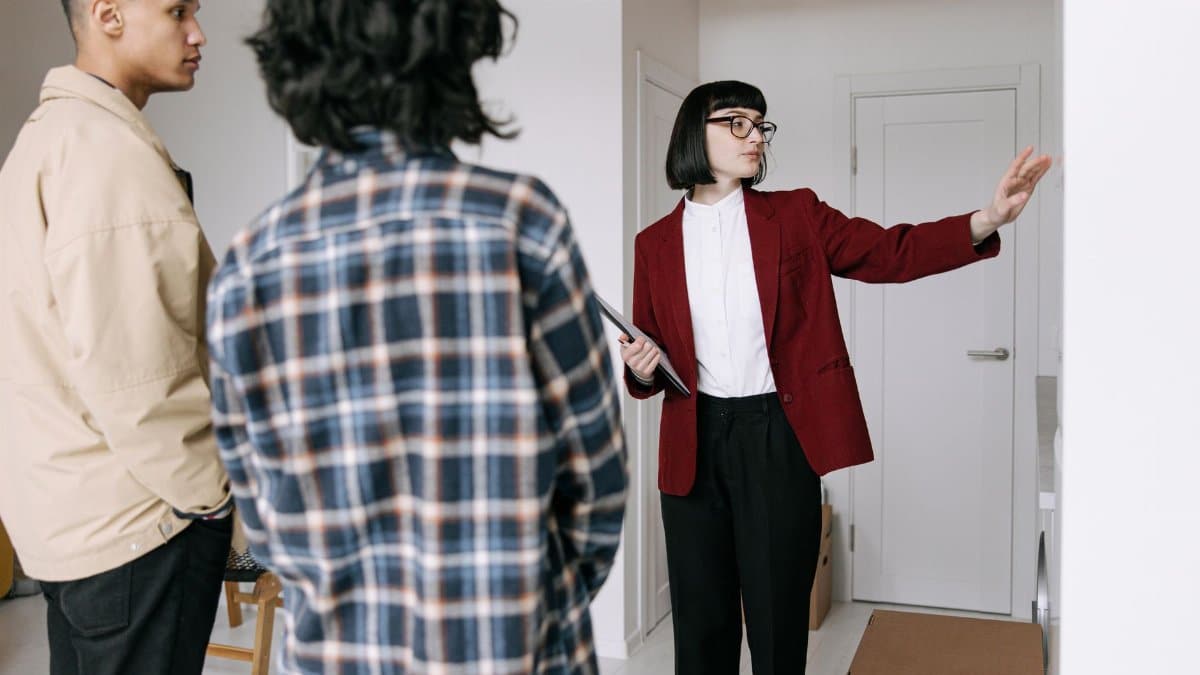 Real estate agent presenting an apartment to potential buyers during a property tour.