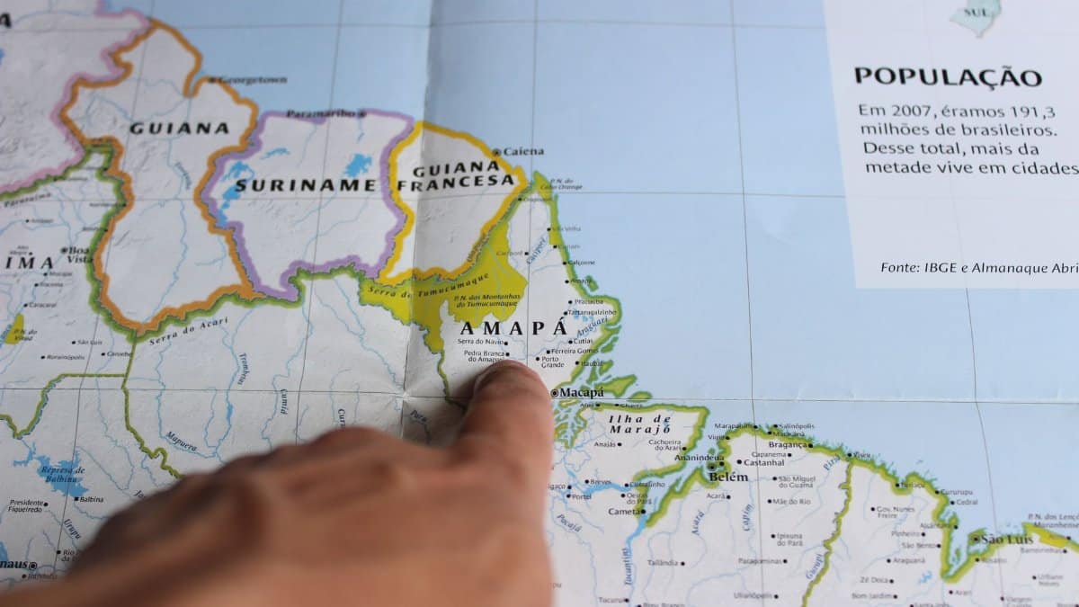 Close-up of a finger pointing at Amapá on a map of Brazil, highlighting geography.