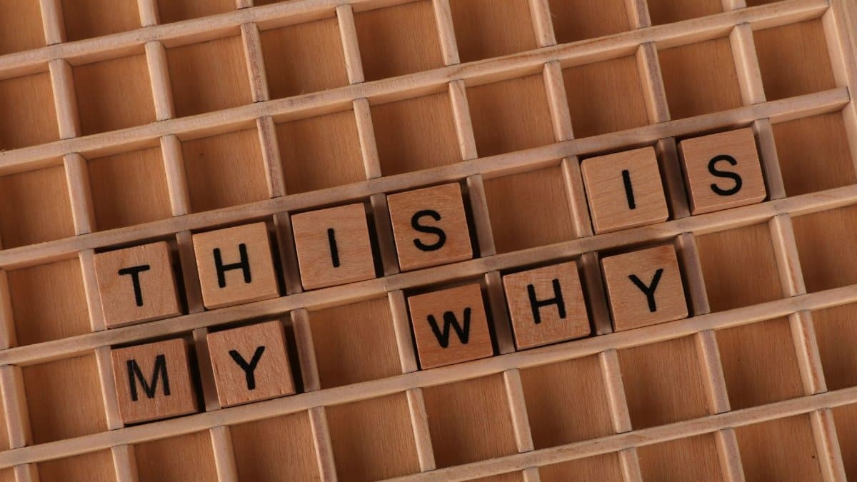 Wooden Scrabble tiles arranged to spell 'This is My Why' on a game board.