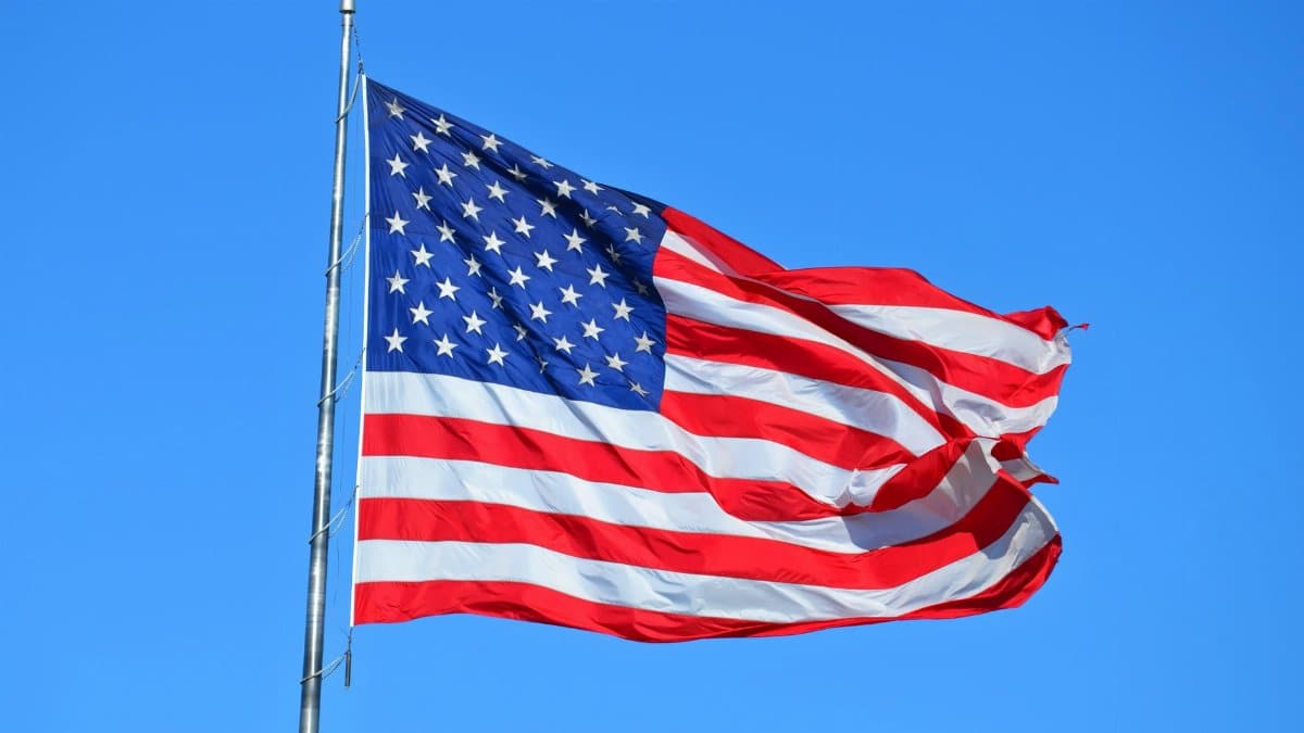 Majestic American flag waving against a bright blue sky, symbolizing freedom and patriotism.