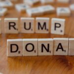 Close-up of Scrabble tiles spelling 'Donald Trump' on a wooden table.
