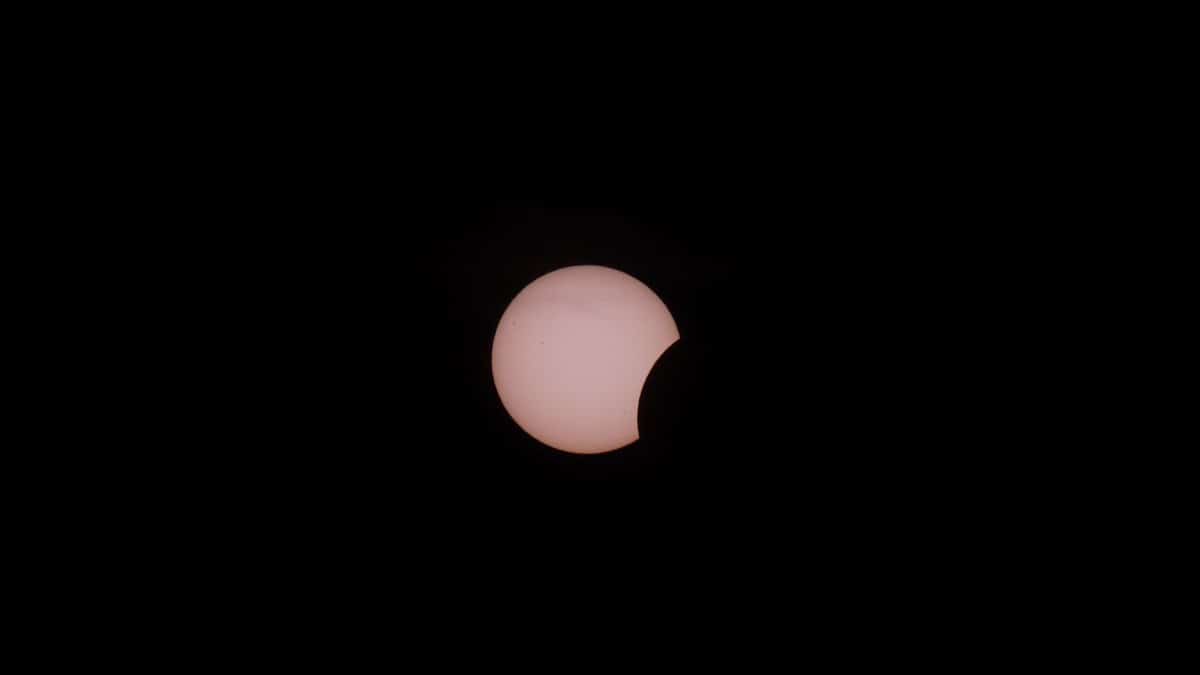 Capturing a partial solar eclipse with the moon obscuring the sun.