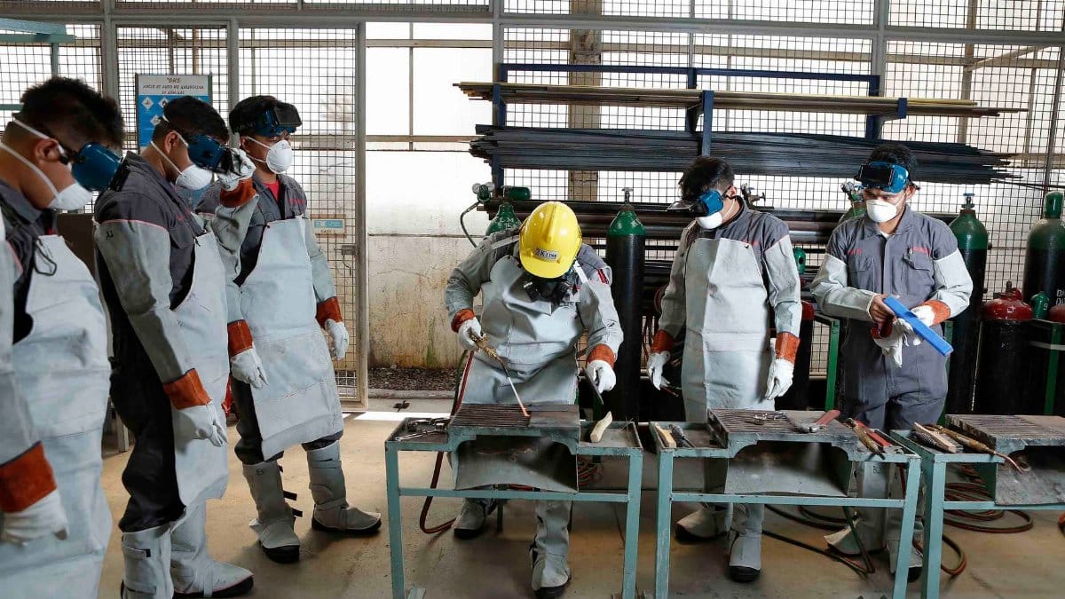 Group of workers in protective gear engaged in factory training in the Philippines.