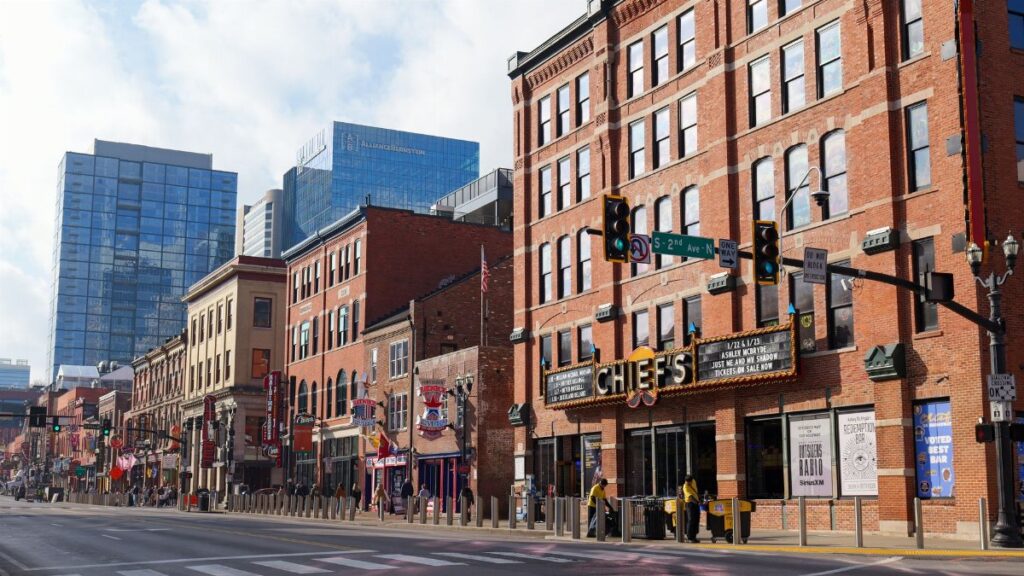 Explore the lively streets of downtown Nashville, showcasing historic brick buildings under a bright sunny sky.