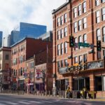 Explore the lively streets of downtown Nashville, showcasing historic brick buildings under a bright sunny sky.