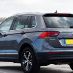 Rear view of a gray Volkswagen Tiguan SUV parked in an urban setting, showcasing modern design.