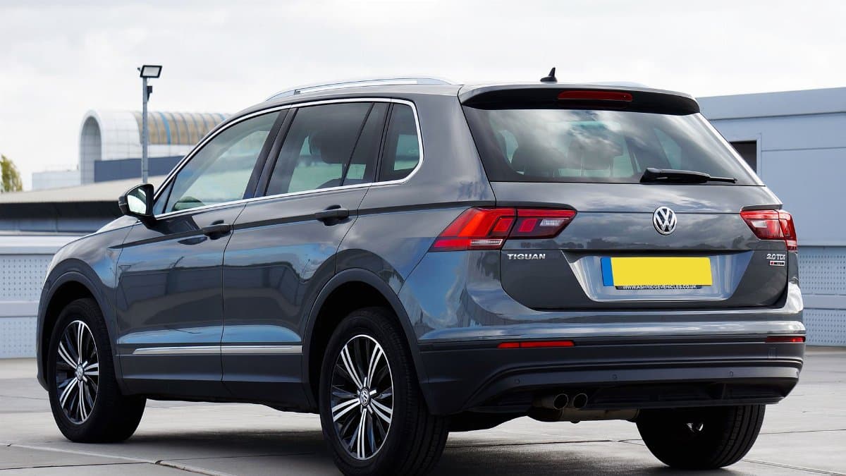 Rear view of a gray Volkswagen Tiguan SUV parked in an urban setting, showcasing modern design.