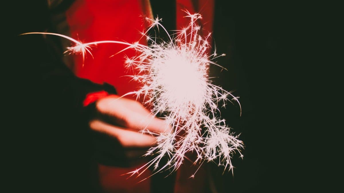 Vibrant and festive sparkler in a hand, illuminating the night with bright sparks.