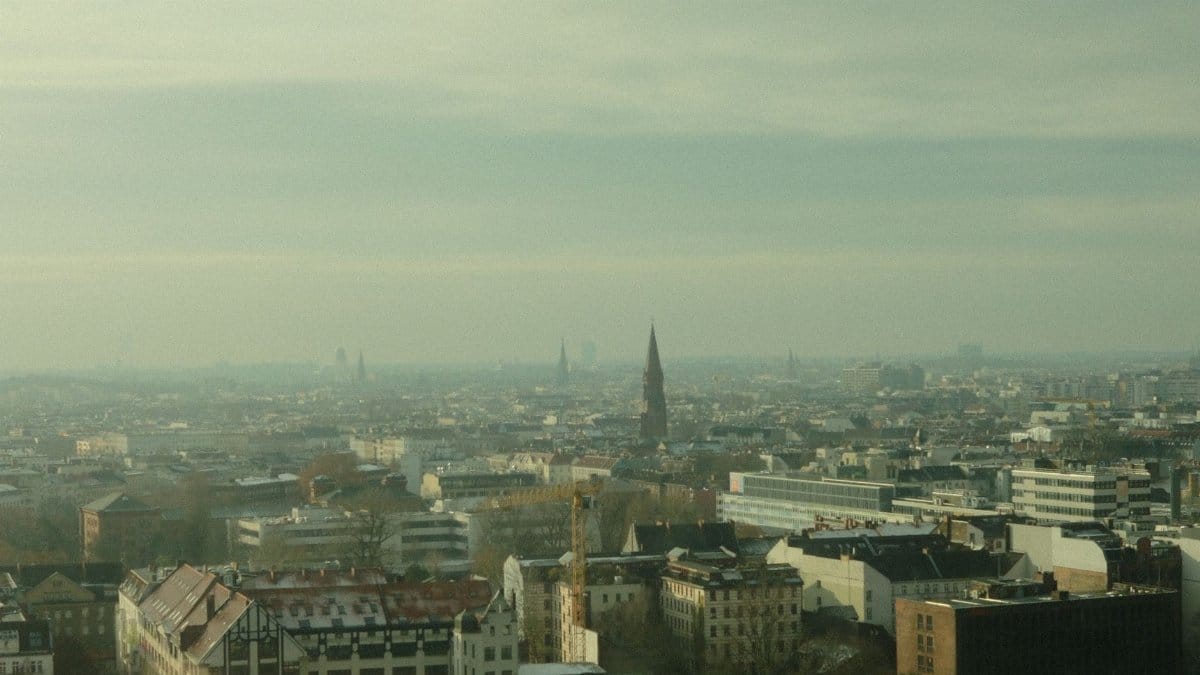 Scenic aerial view of Berlin, Germany, showcasing the city skyline and Spree River under an overcast sky.