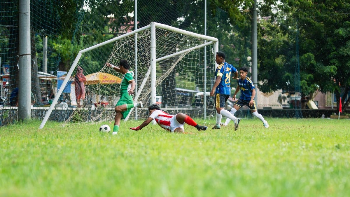 A thrilling moment in a youth soccer match with players passionately competing to score a goal on a grass field.